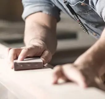 Closeup of man laying down new flooring