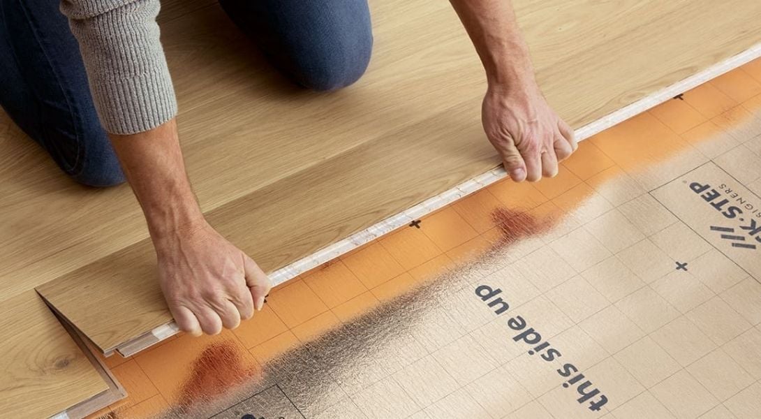 Flooring installer installing Quick Step Laminate in home